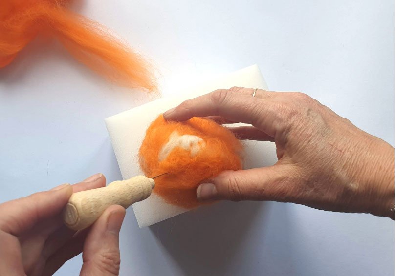Zapracování oranžové vlny do bílého plstěného podkladu