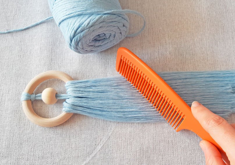 Přidání modrých přízí a rozčesávání macramé anděla